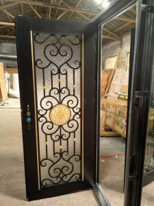  Black Wrought-iron entry Door with an intricate gold and black Scrollwork glass insert