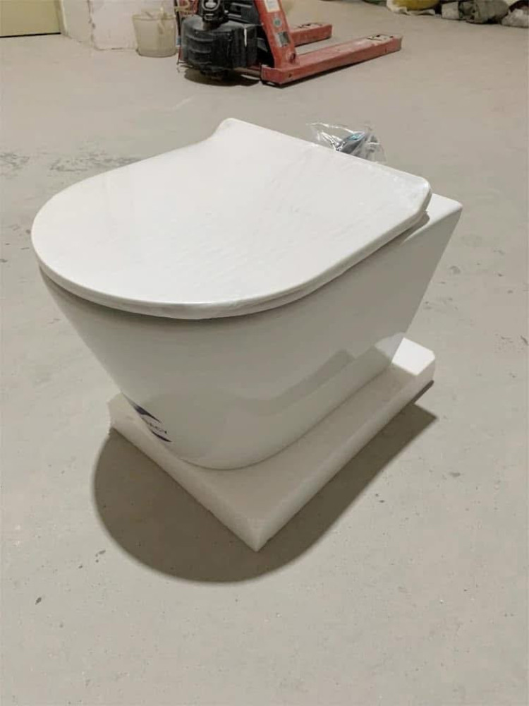 Modern wall-hung toilet with a concealed cistern and a black tempered glass panels