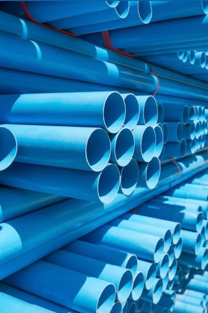 Large Stacks of blue PVC pipes in a ware house setting