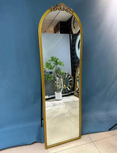 Gold-framed arched standing floor mirror