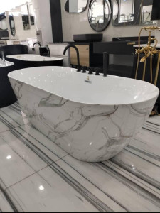 Freestanding soaking bahtub with a white and gray marble pattern exterior and solid white interior