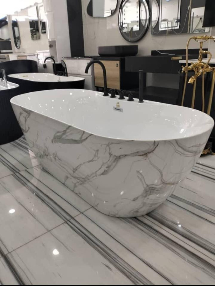 Freestanding soaking bahtub with a white and gray marble pattern exterior and solid white interior