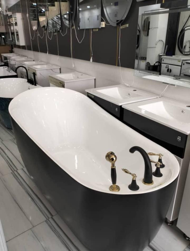 Black and White curved Luxury freestanding bathtub with a black and gold faucet set