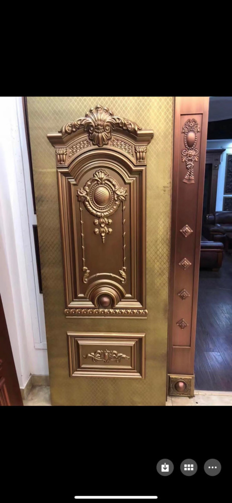 Embossed Metal Security Door with an ornate classical design and a gold or bronze-toned finish