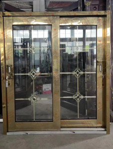 Gold-framed glass sliding door with decorative metalwork