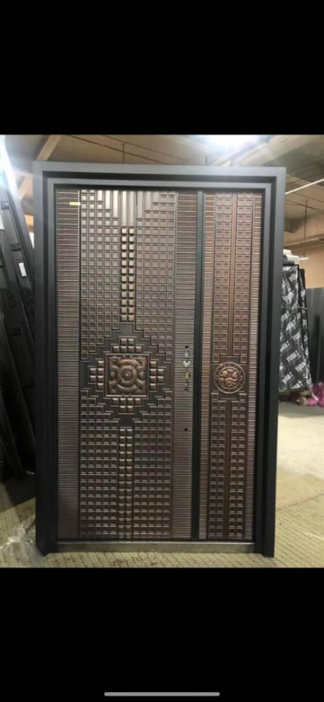 Double Steel Security Door with copper or bronze finish with distinctive pattern of raised square panels and horizontal lines