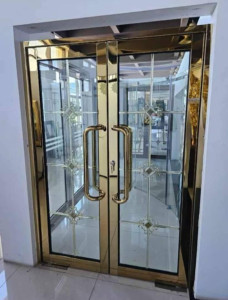 Double glass Doors with a gold-coloured frame and handles