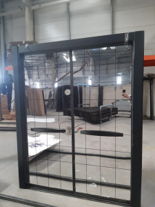 Black metal-framed Sliding Security Door with a glass panel and a grid pattern