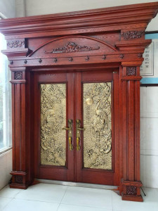 Large ornate Wooden Double Door with intricate gold-coloured metal inlays 