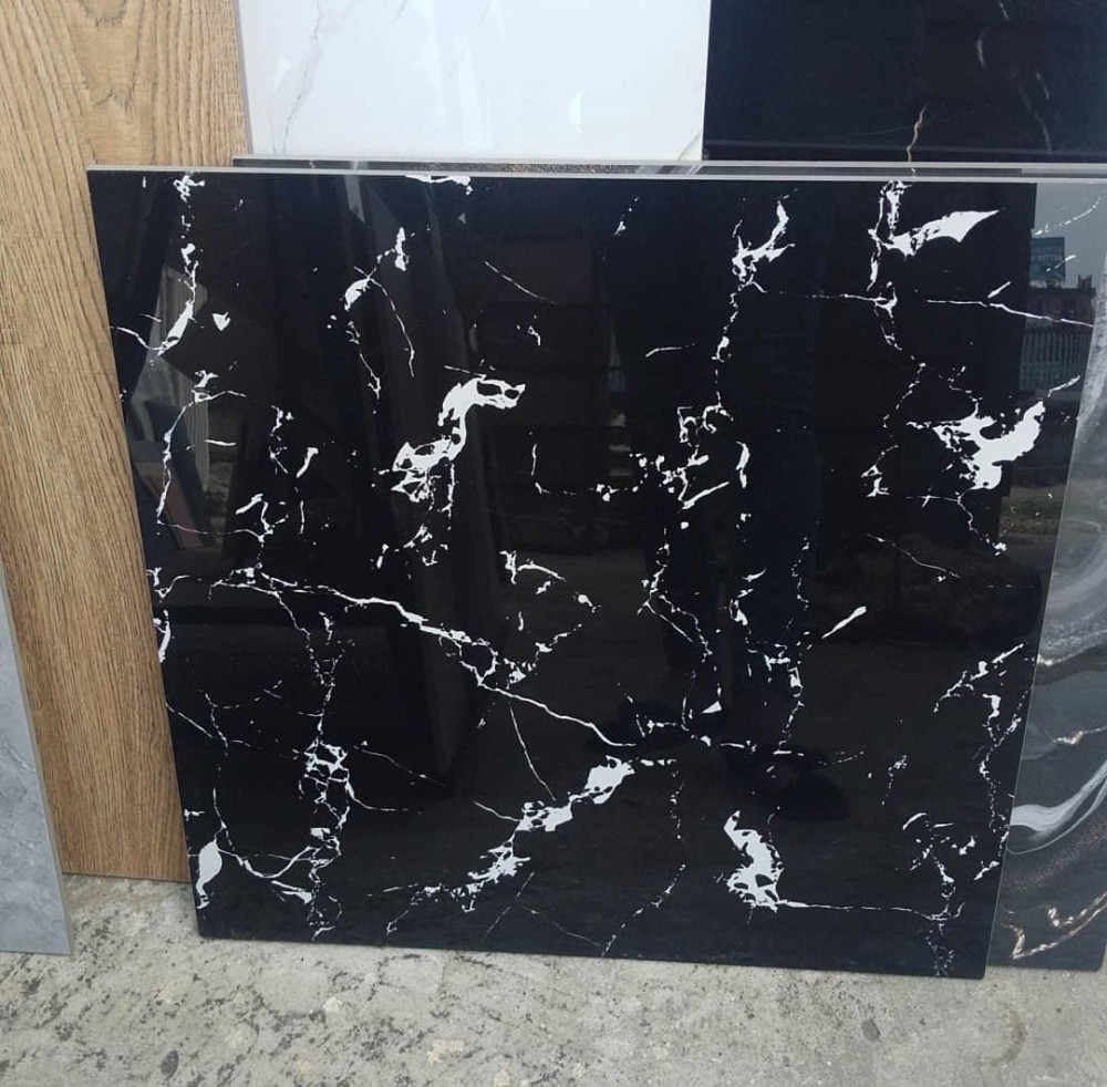 Glossy black porcelain floor tile featuring white marble-look veining 