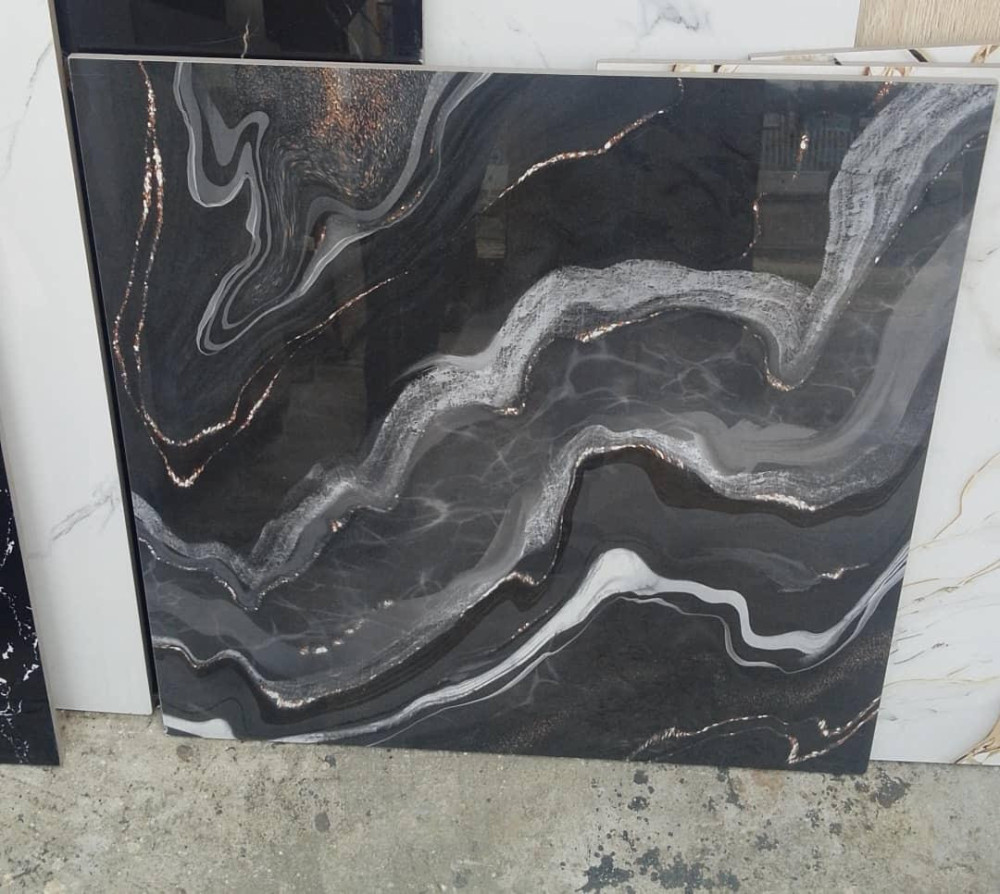 Polished black tile or slab with dramatic white and gold veining 