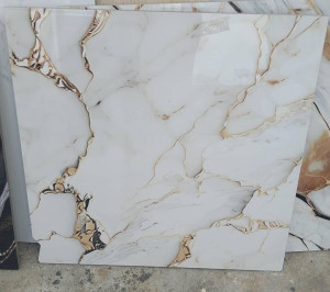 Polished procelain stoneware tile with a white background and gold veining 