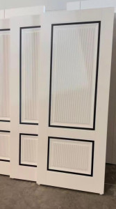 White Interior door with black trim and vertical fluted panels