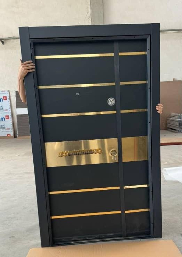 Black Security Door with Gold horizontal bands and a large gold pull handle